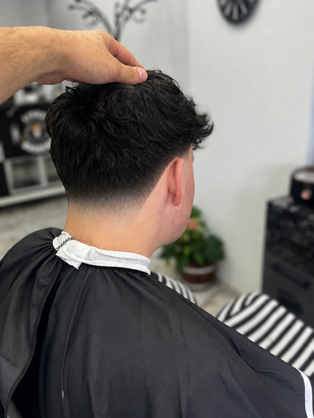 Taper fade van achteren, terwijl de bovenkant in model wordt gebracht
